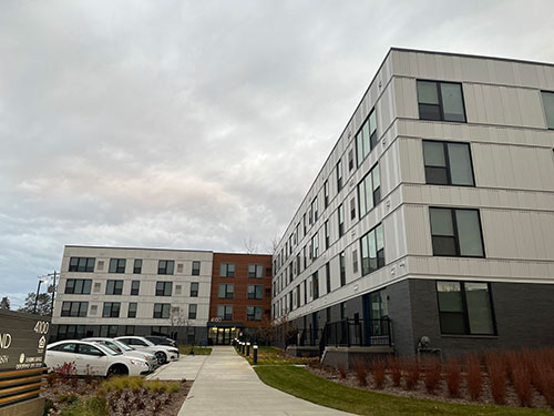 White apartment building with parked cars