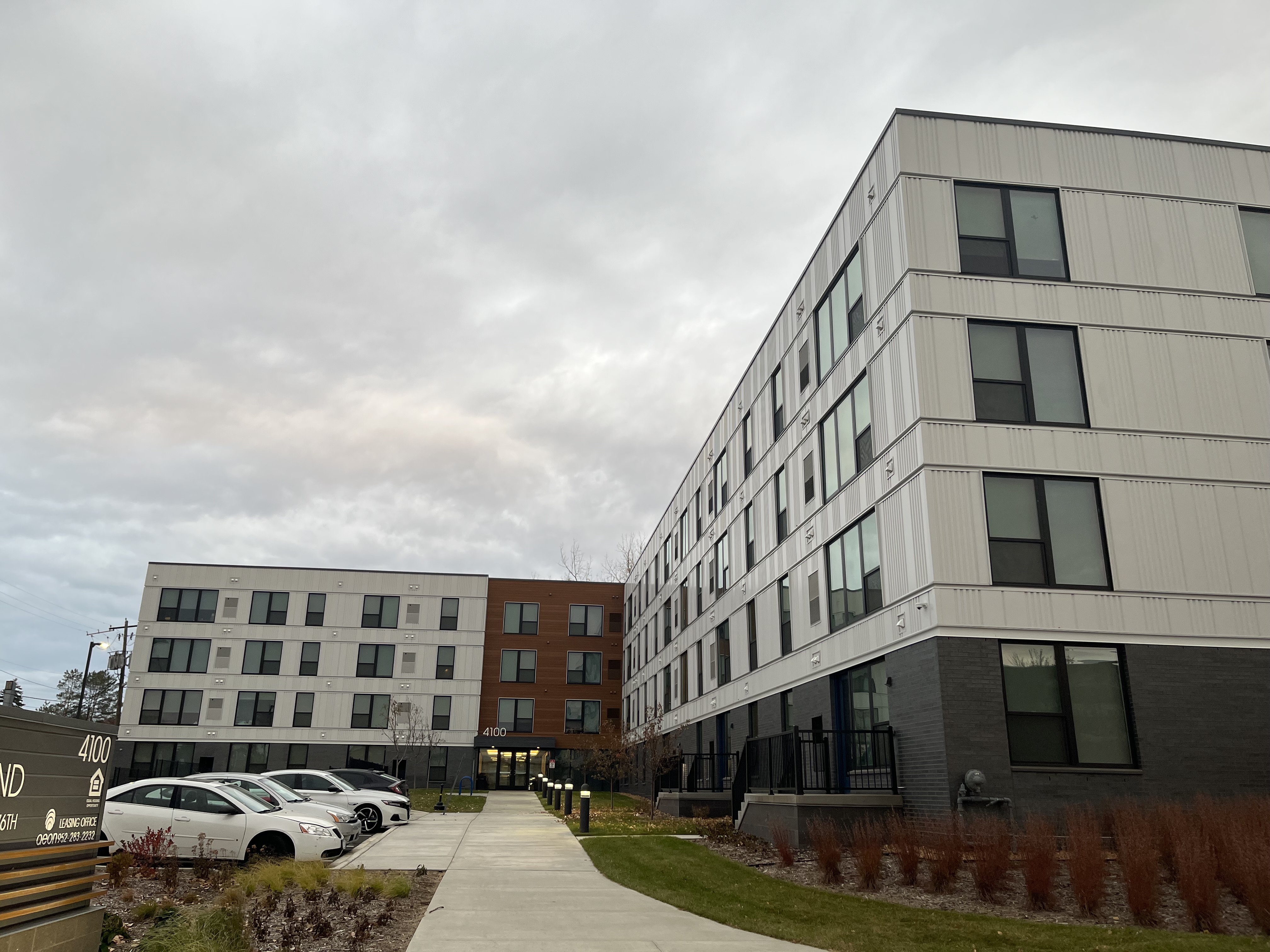 White apartment building with parked cars