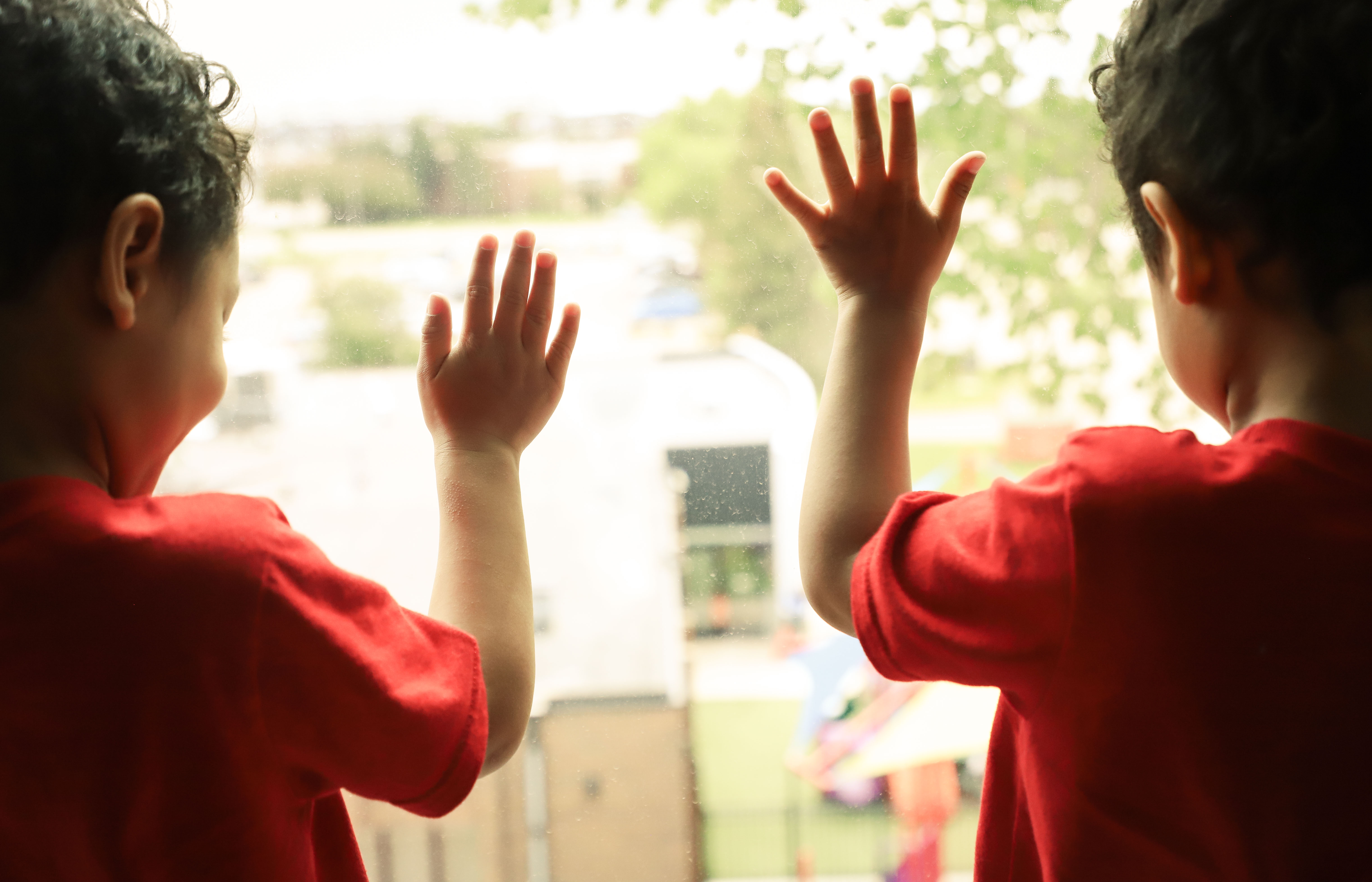 Children_hands_on_window
