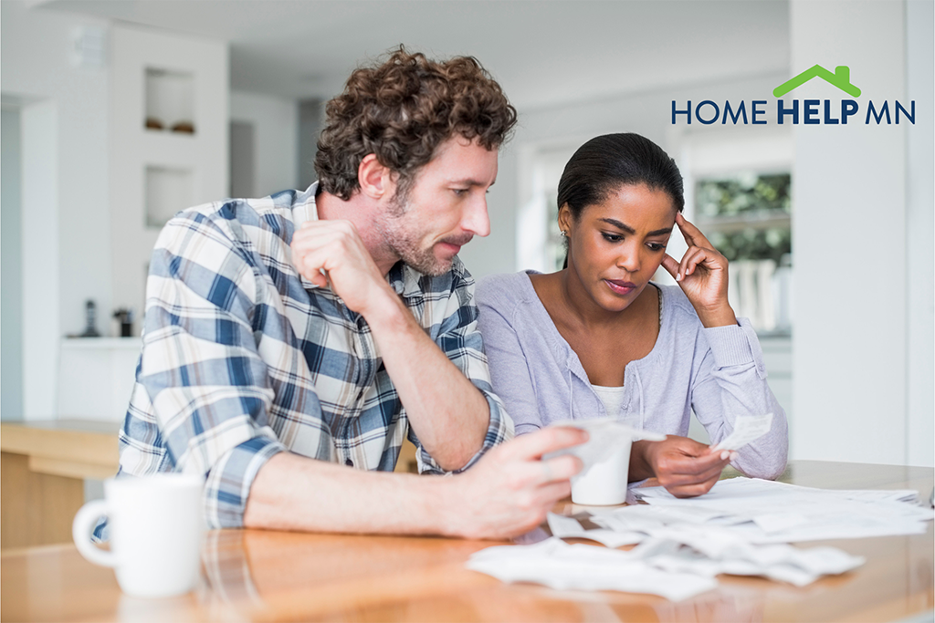 Couple_looking_at_bills_with_HomeHelpMN_logo